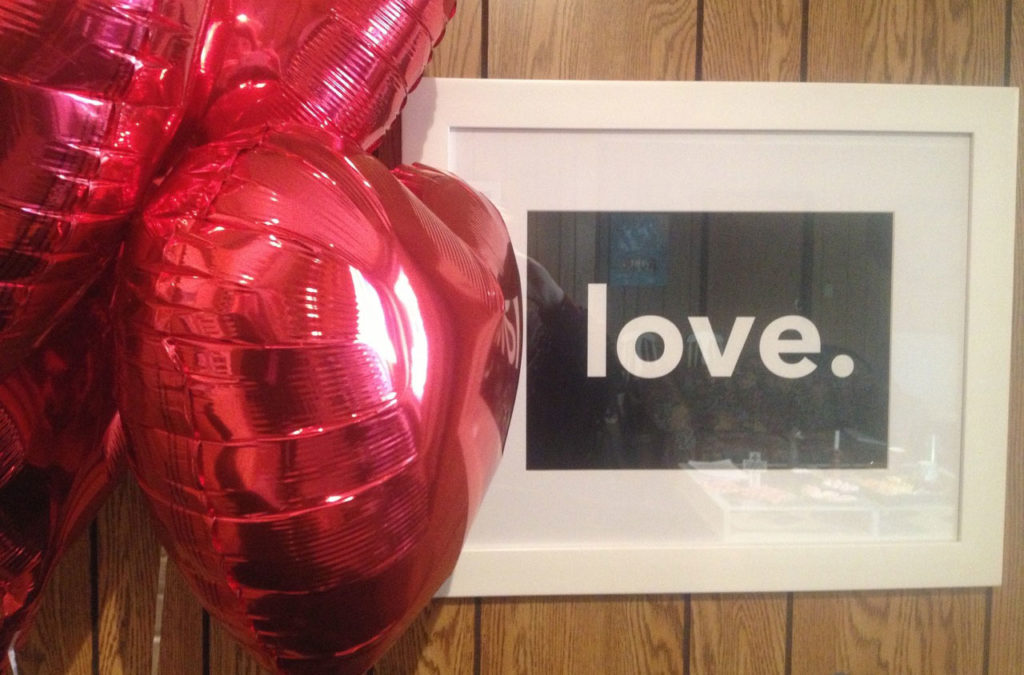 Framed word 'love' next to heart balloons